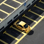 gelbes Fahrzeug alleine auf Parkplatz